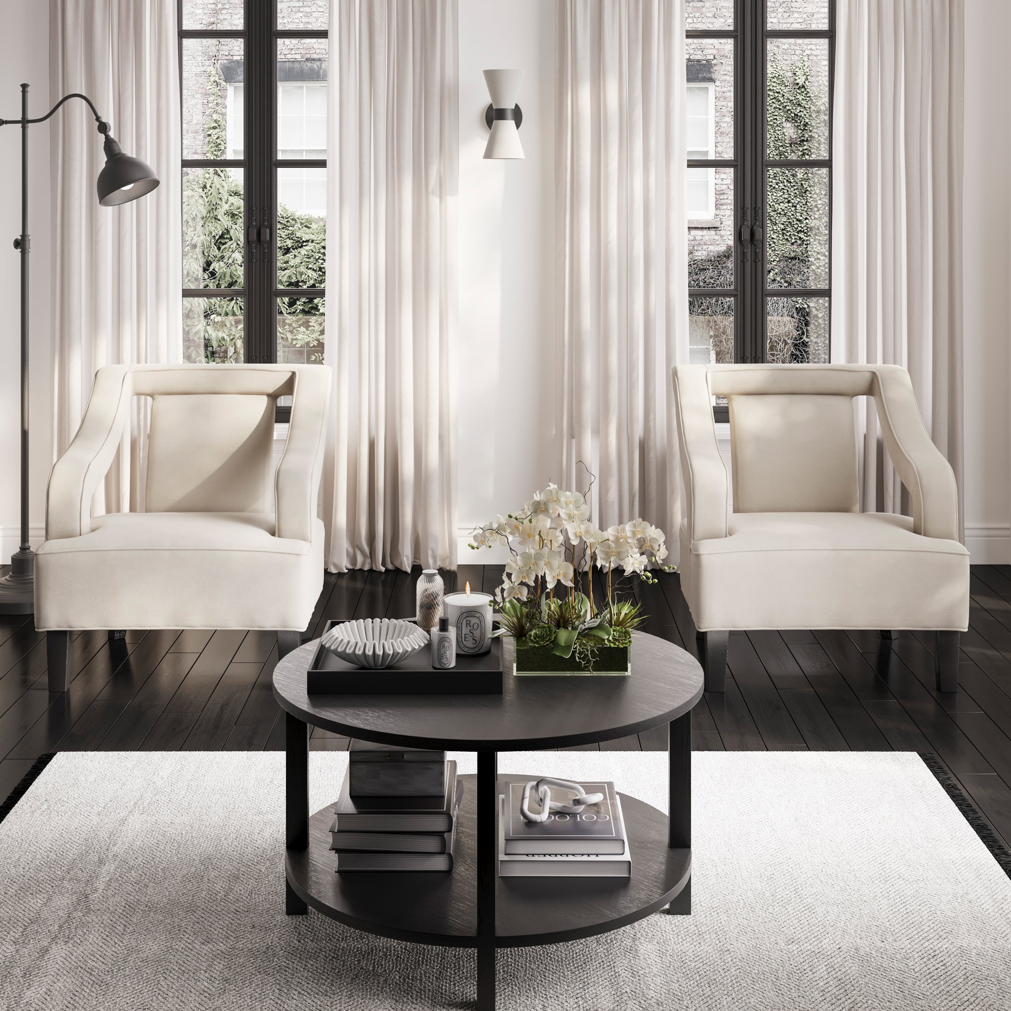 Modern living room with white armchairs and a round black coffee table.