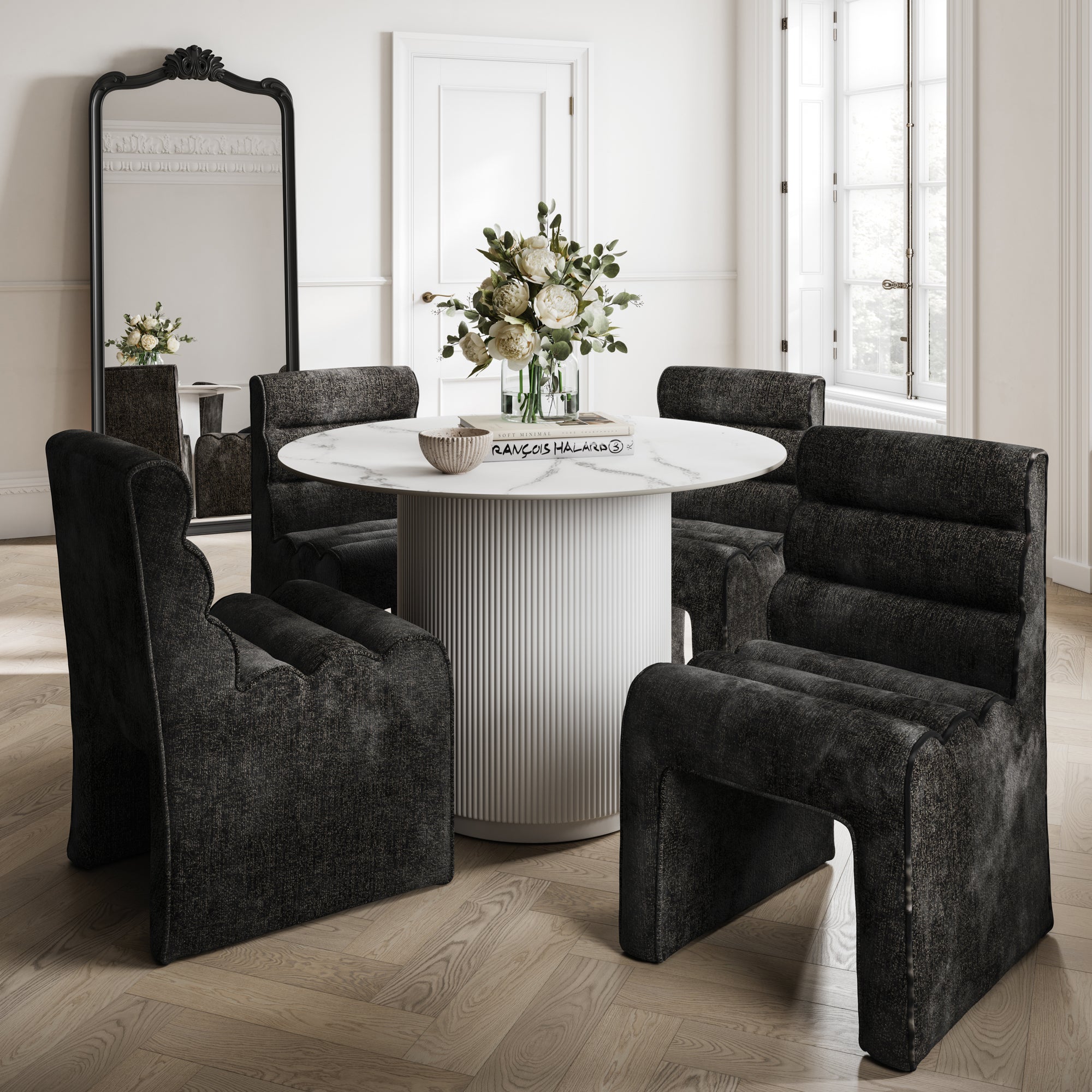 Round marble effect table with a white base and black velvet chairs